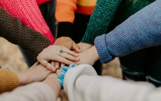 braccia in cerchio con la mano tesa al centro come simbolo di unione